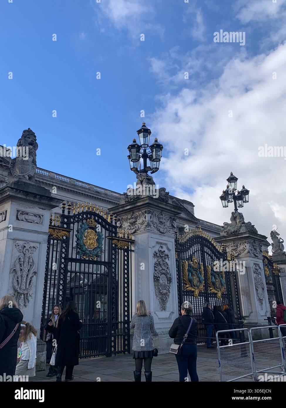 Une vue sur les grandes portes ornementales du palais de Buckingham, ornée de ferronneries complexes et d'insignes royaux. - Image de stock capturée avec un smartphone