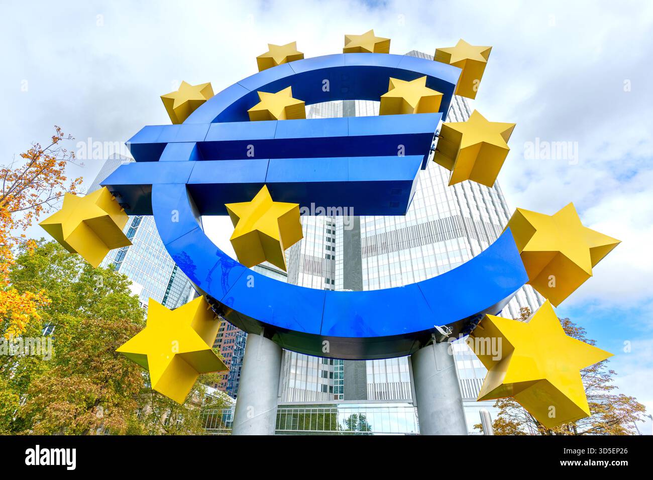 Francfort, Allemagne - 21 octobre 2025 : une sculpture de signe Euro bleu proéminente avec des étoiles jaunes domine le cadre, contre le haut-ris contemporain Banque D'Images