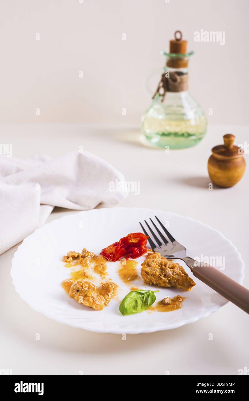 Arrêtez le gaspillage alimentaire. Restes de nourriture sur une assiette après le dîner sur la vue verticale de la table Banque D'Images