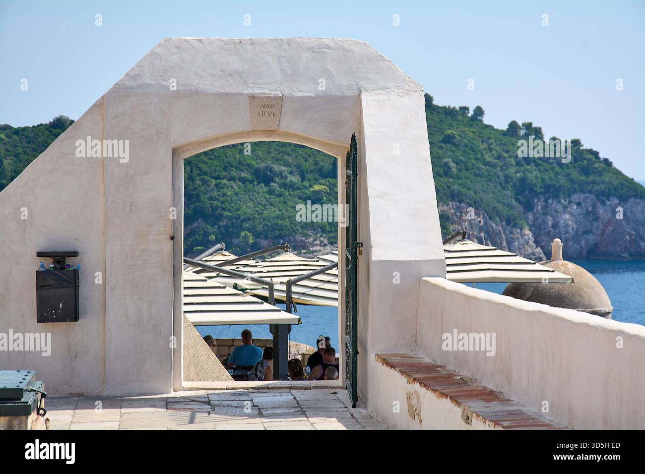 Dubrovnik. Croatie - 15 novembre 2025 : les touristes prennent un verre au célèbre Buza Bar, un café à flanc de falaise accessible par une arche dans la vieille ville Banque D'Images