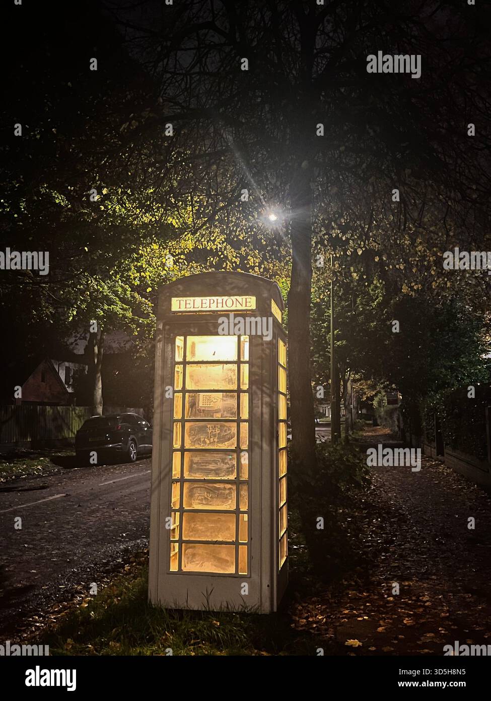 Cabine téléphonique britannique traditionnelle éclairée la nuit à Hull, Angleterre. Symbole emblématique du Royaume-Uni capturé dans un cadre urbain calme, parfait pour voyager - Image de stock capturée avec un smartphone