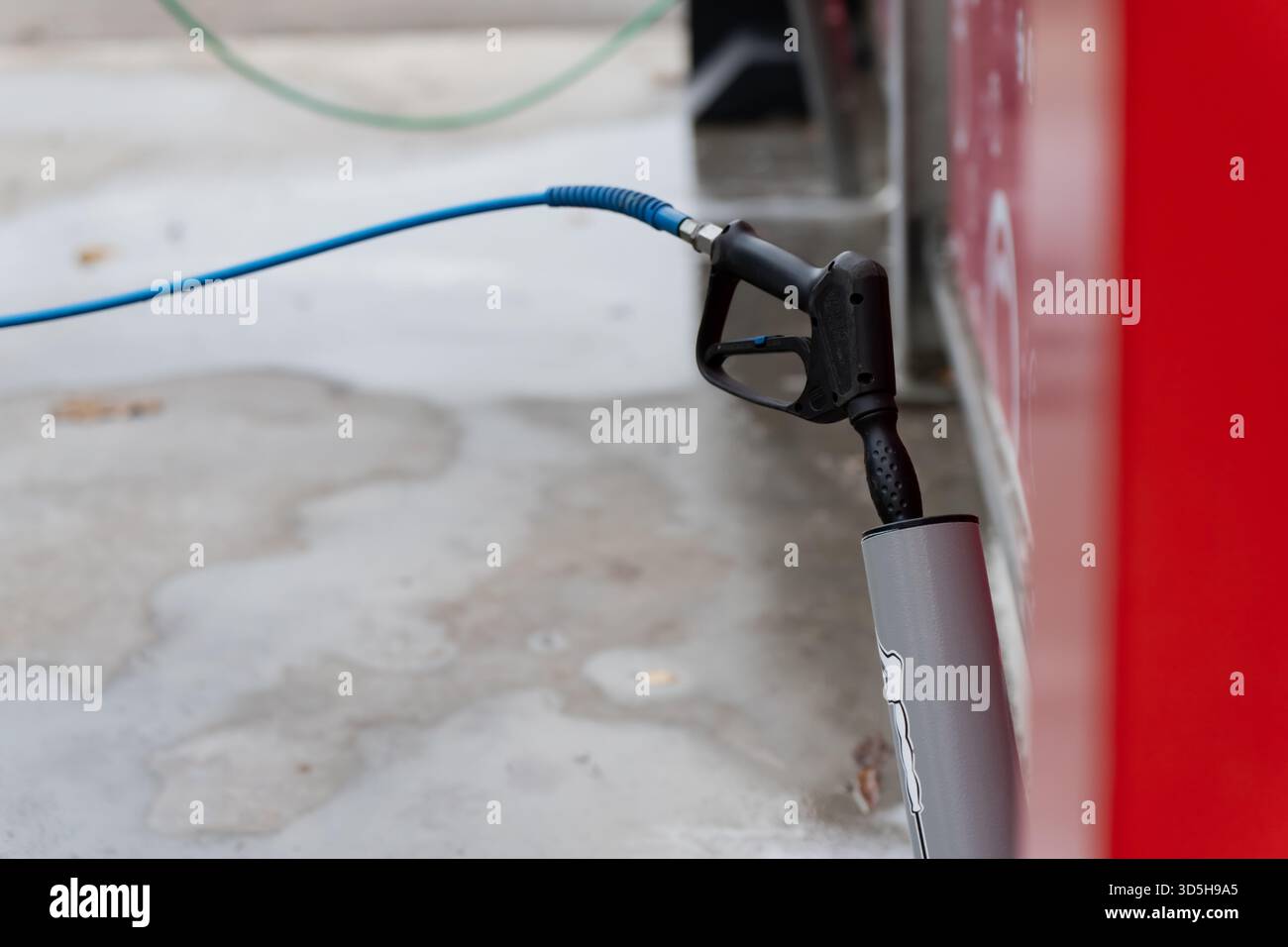 Tuyau pneumatique et buse d'air situés à proximité du panneau d'équipement au niveau du sol, mettant en évidence la configuration de l'atelier, le raccordement d'air comprimé et la fonctionnalité Banque D'Images