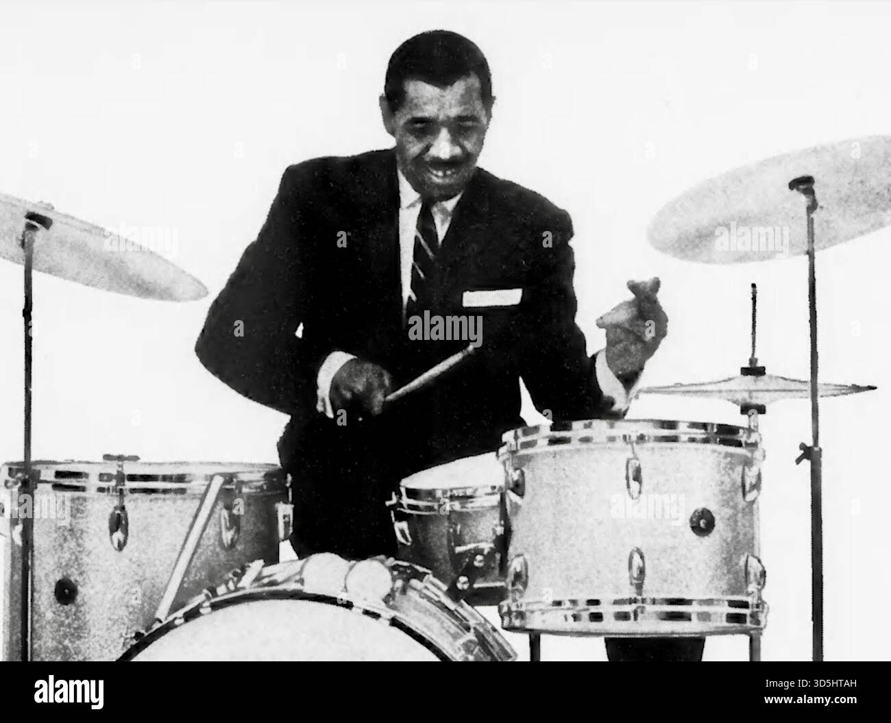 Joseph Rudolph 'Philly Joe' Jones, un batteur de jazz américain influent. Il est surtout connu pour son travail en tant que batteur du premier Quintet 'Great' Miles Davis. Né à Philadelphie en 1923, Jones était un maître de la percussion jazz connu pour son style dynamique et 'électrisant'. Il tourne et enregistre avec le Miles Davis Quintet de 1955 à 1958, contribuant à des albums historiques comme Round Midnight, Cookin' et Milestones. Le jeu de Jones a été très influent, et ses techniques, y compris l'utilisation de rudiments spécifiques de tambour-piège, sont encore étudiées par les étudiants de jazz dans le monde entier. Banque D'Images