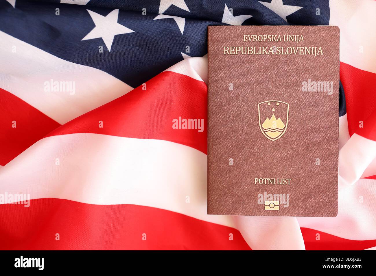 Passeport slovène sur grand drapeau agitant des États-Unis d'Amérique close up. Visa AMÉRICAIN et concept d'immigration Banque D'Images