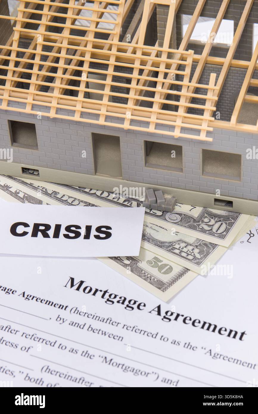 Petite maison de jouet inachevée, formulaire d'accord hypothécaire, billets de dollars et crise d'inscription. Prix élevés de l'immobilier et de la construction de maison Banque D'Images