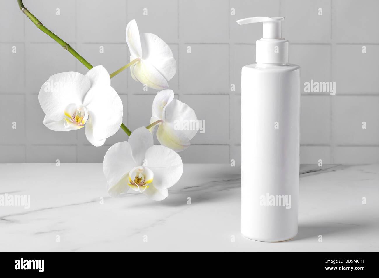 Une bouteille avec un produit cosmétique pour les soins de la peau du corps sur le fond d'une orchidée florissante. Mise au point sélective Banque D'Images