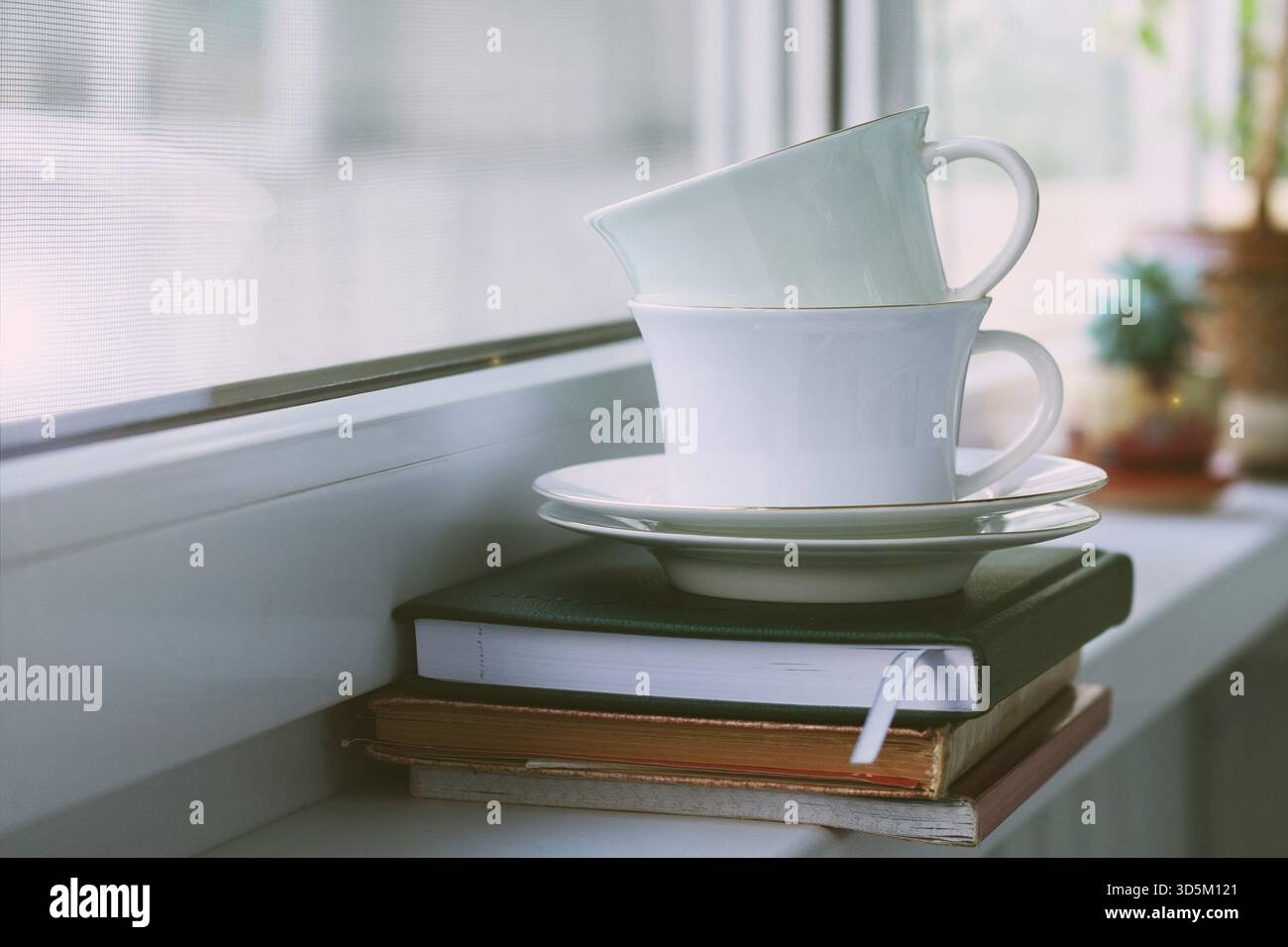Composition de deux tasses à thé en porcelaine avec soucoupes sur le rebord de la fenêtre. Mise au point sélective Banque D'Images