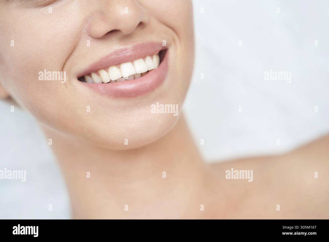 Gros plan de femme caucasienne souriante avec des dents parfaites et une peau lisse Banque D'Images