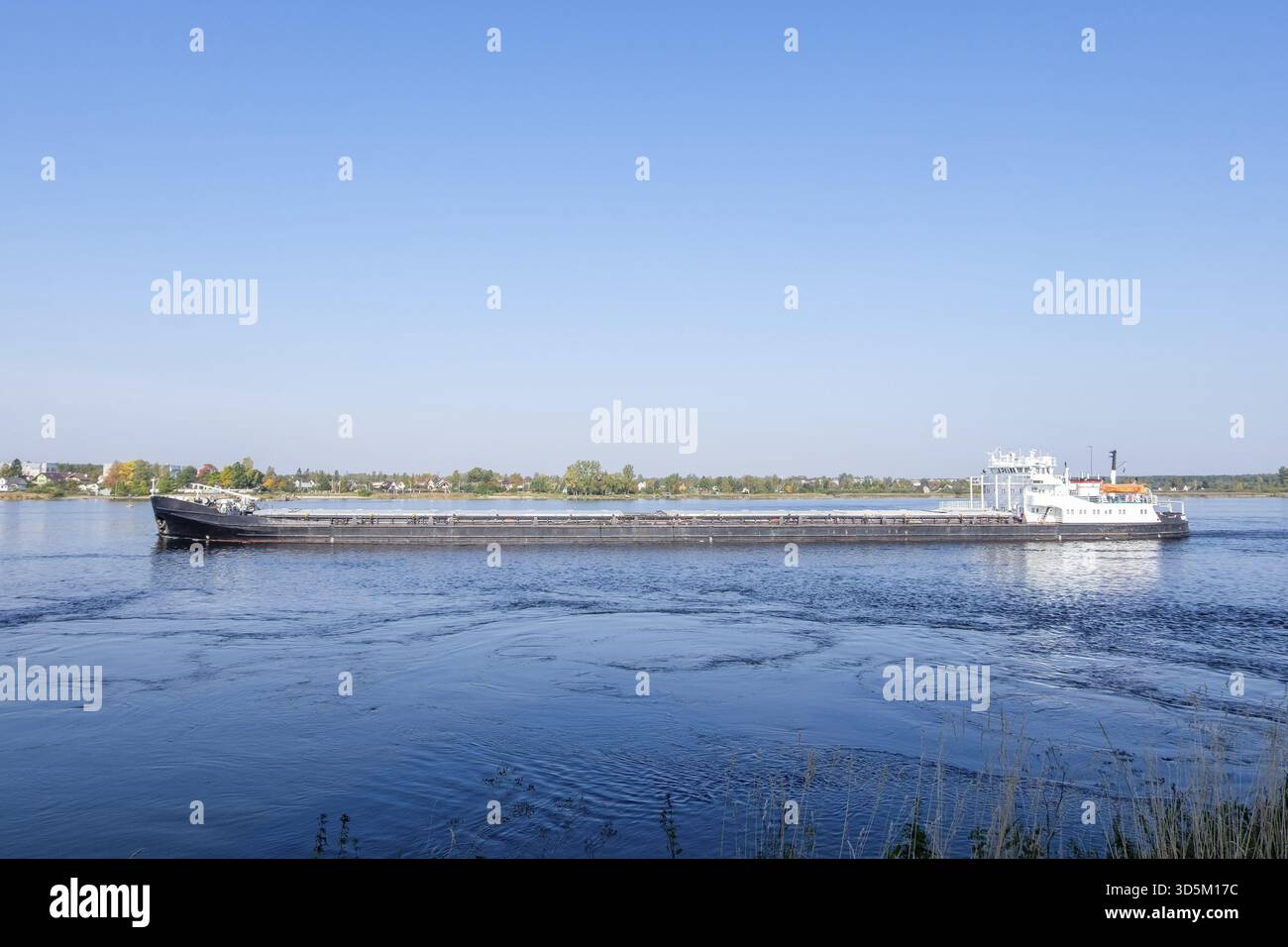 Le navire commercial de marchandises sèches navigue le long de la rivière en été ou au début de l'automne. Orientation horizontale, mise au point sélective Banque D'Images