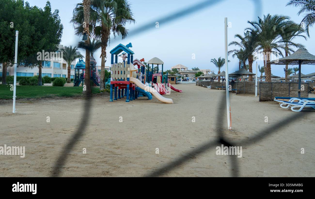 L'équipement de jeu coloré pour enfants dans un complexe égyptien crée un espace joyeux et accueillant pour le plaisir en plein air et la détente en famille. Banque D'Images