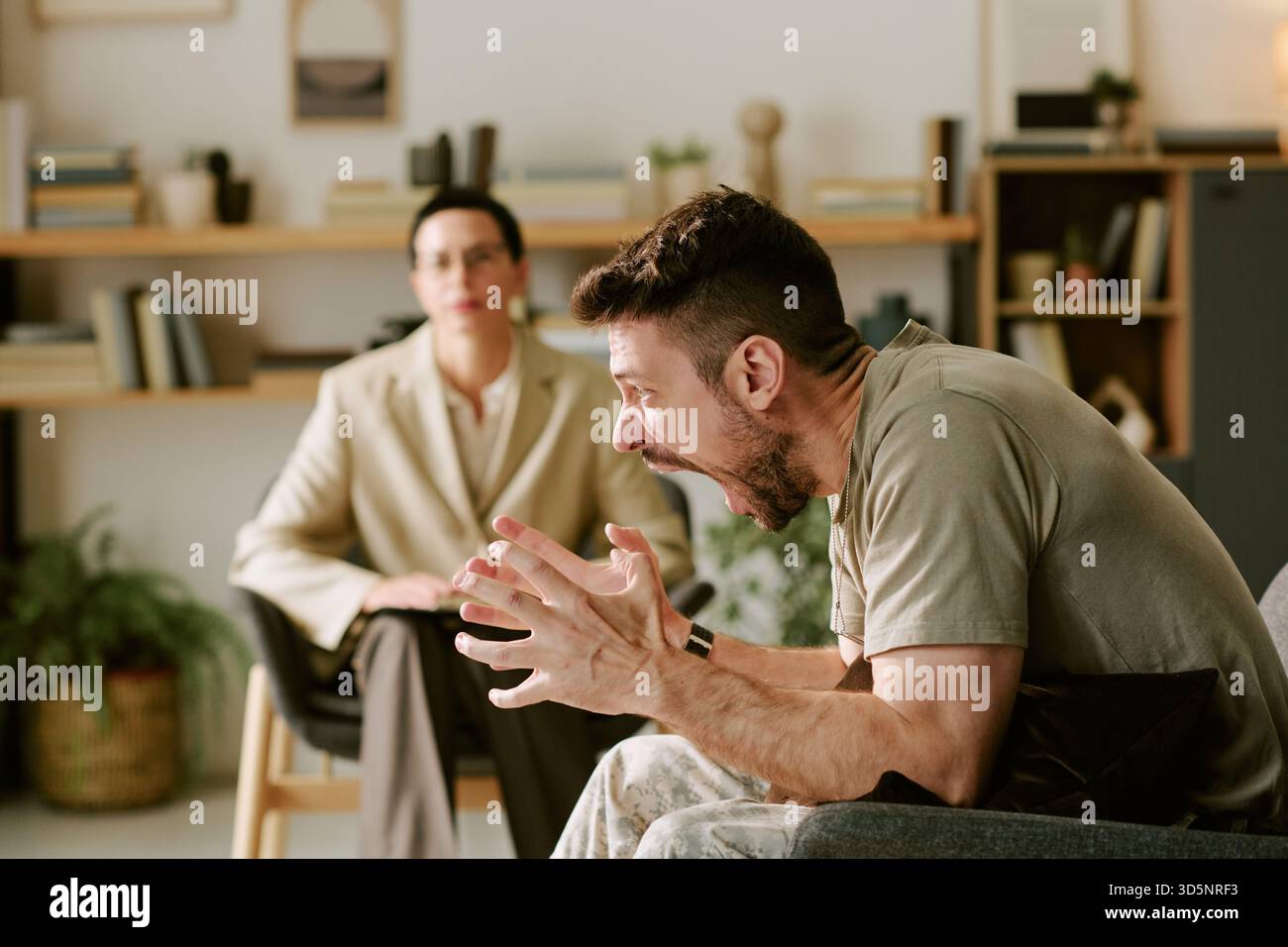 Jeune homme caucasien exprimant la colère pendant la séance de thérapie avec le psychologue Banque D'Images
