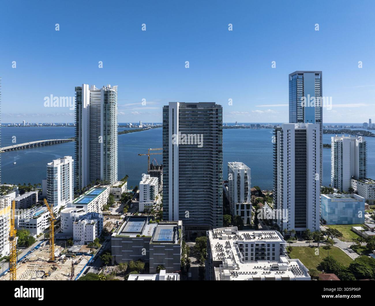 Vue aérienne de gratte-ciels scintillants perçant le ciel bleu clair, surplombant la vaste baie et les ponts lointains, un paysage urbain dynamique se déploie, Edgewate Banque D'Images