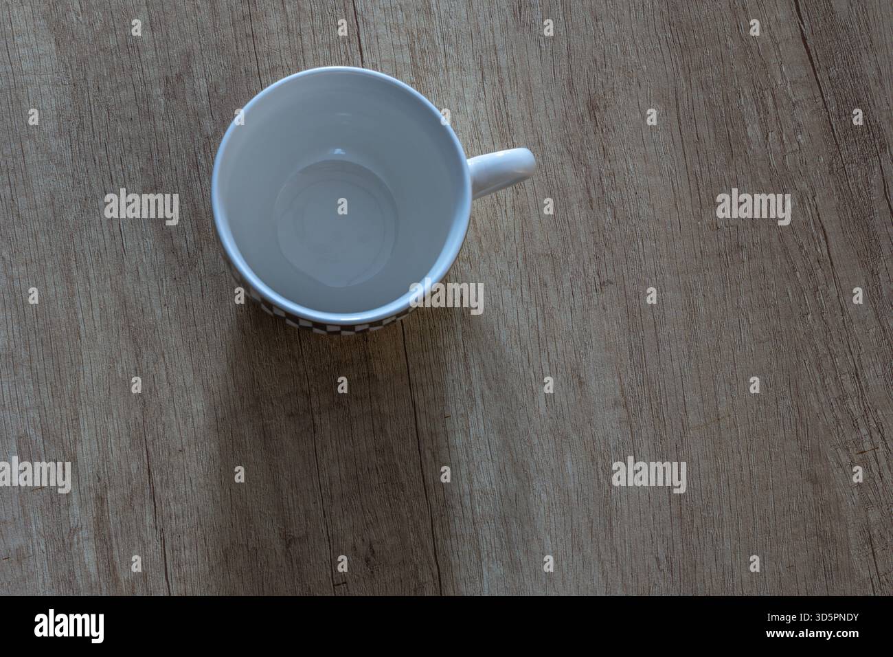 Tasse à café vide blanche sur un comptoir en bois, vue de dessus Banque D'Images