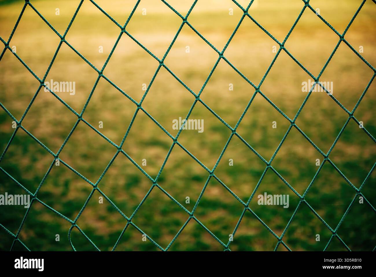 Gros plan de filet vert de terrain de football, texture détaillée de fibres synthétiques tissées. Mise au point sélective. Banque D'Images