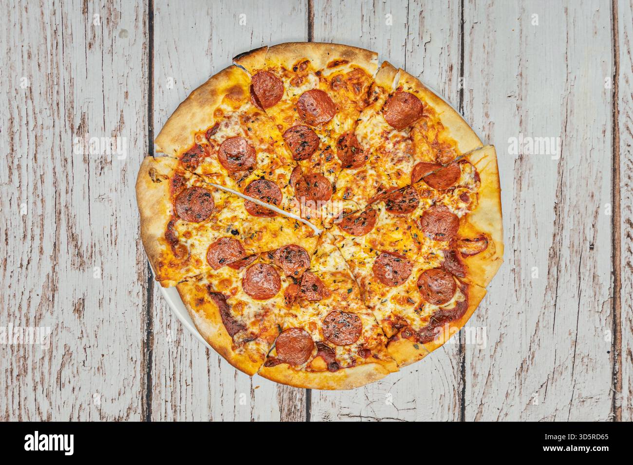 La graisse du salami épicé a légèrement fondu sur le fromage, créant de petits cratères de saveur intense et un aspect juteux et appétissant. Banque D'Images