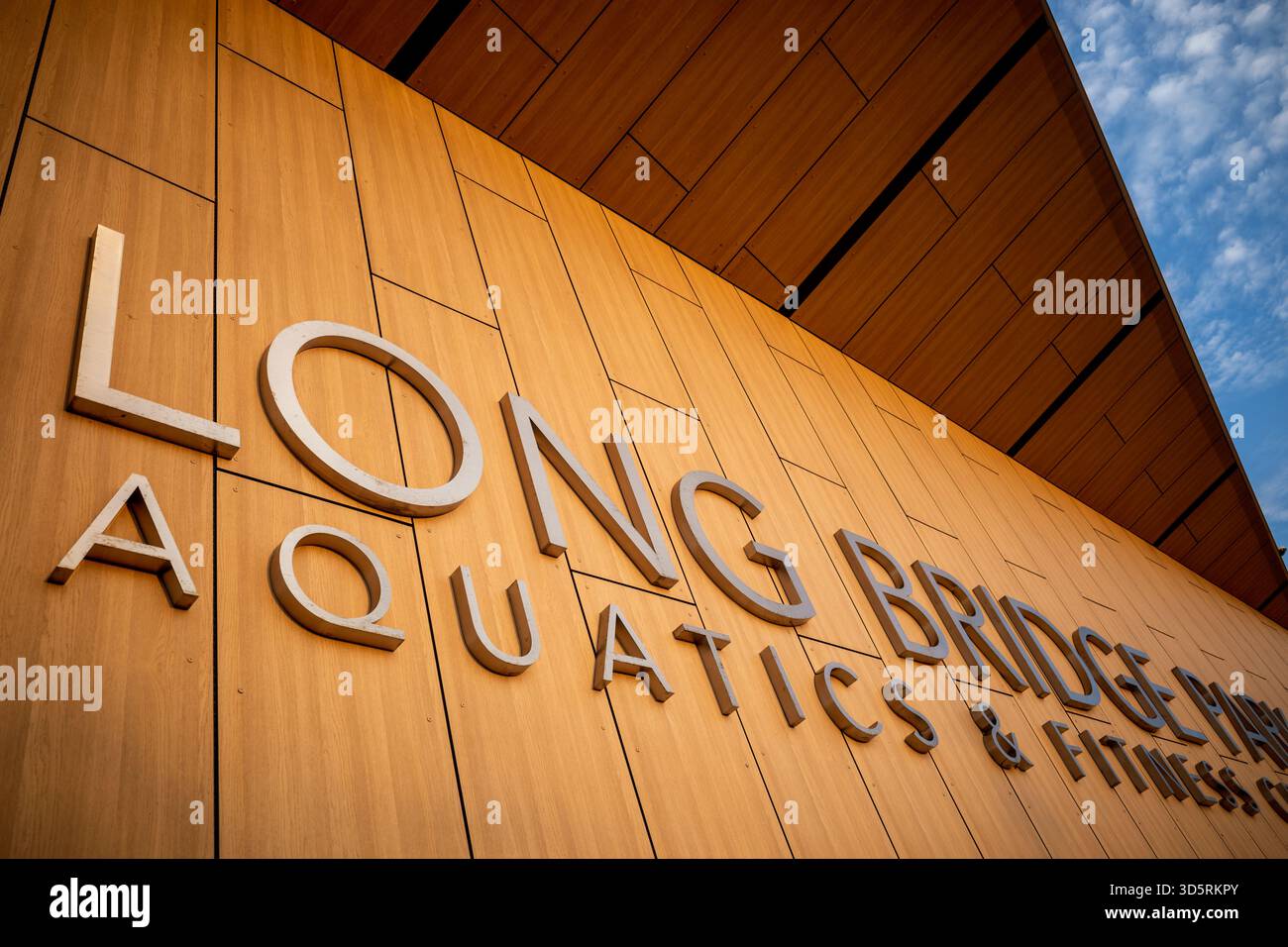 Long Bridge Park Aquatics and Fitness Center Arlington Virginia // ARLINGTON, Virginia — la signalisation extérieure du long Bridge Park Aquatics and Fitness Center est affichée sur sa façade moderne lambrissée. Cet établissement public offre des équipements aquatiques et de conditionnement physique à la communauté d'Arlington, en Virginie. Ouvert en 2021, il est un élément important du long Bridge Park. Le centre offre des piscines ultramodernes, un espace de conditionnement physique et divers espaces de loisirs. Il sert de centre récréatif clé pour les résidents et les visiteurs de la région métropolitaine de Washington D.C. Banque D'Images