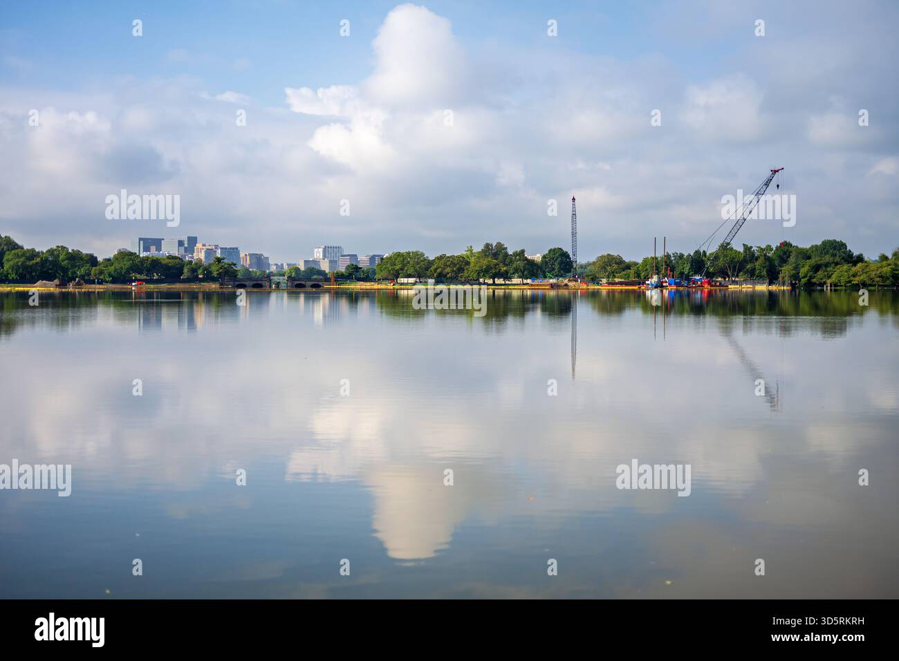 Réparation de la digue de Tidal Basin construction avec Crystal City Skyline Washington DC // WASHINGTON DC — la réparation de la digue de Tidal Basin est en cours, avec la skyline de Crystal City visible de l'autre côté du fleuve Potomac. Ce projet en cours porte sur la détérioration des infrastructures des années 1880, qui provoque des inondations chroniques et menace les célèbres cerisiers. Le Tidal Basin, une crique artificielle de 107 acres (43 hectares), est un élément central du National Mall, entouré de monuments comme le Jefferson Memorial. Crystal City, dans le comté d'Arlington, en Virginie, est devenue une partie importante du Washington M. Banque D'Images