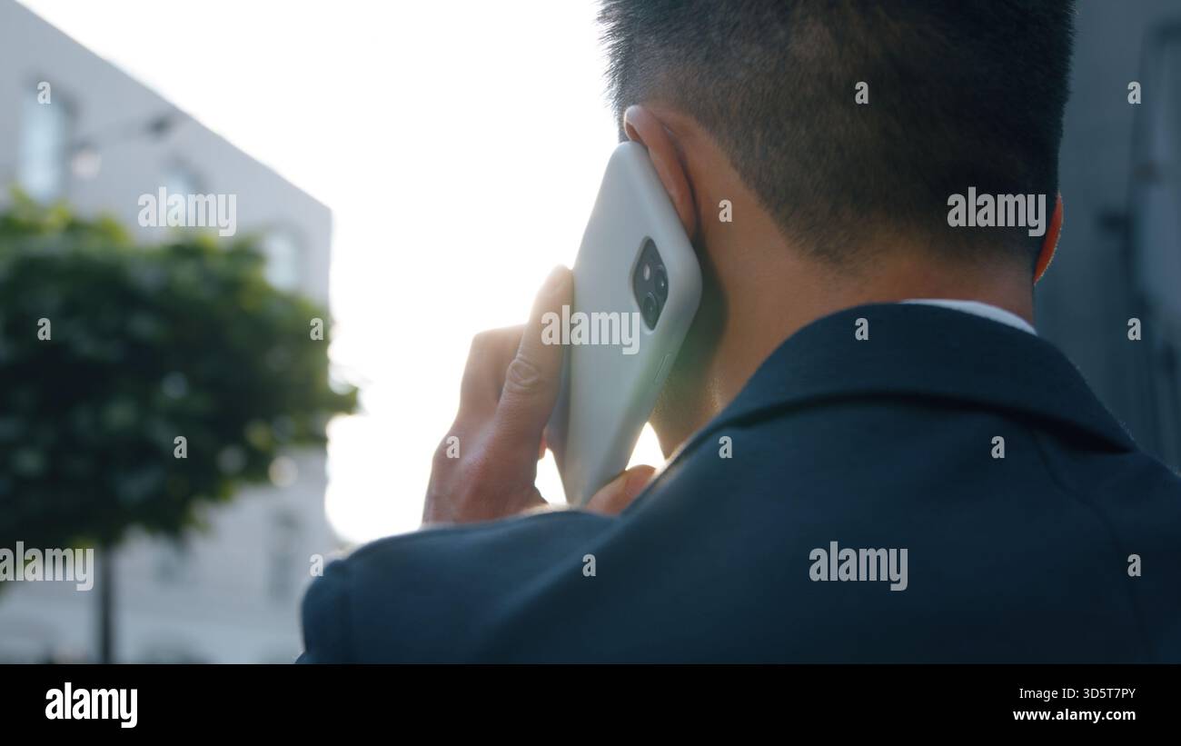 Vue arrière homme d'affaires parlant téléphone mobile appel répondre appel discuter travail homme d'affaires parler smartphone parler asiatique entrepreneur masculin coréen occupé Banque D'Images