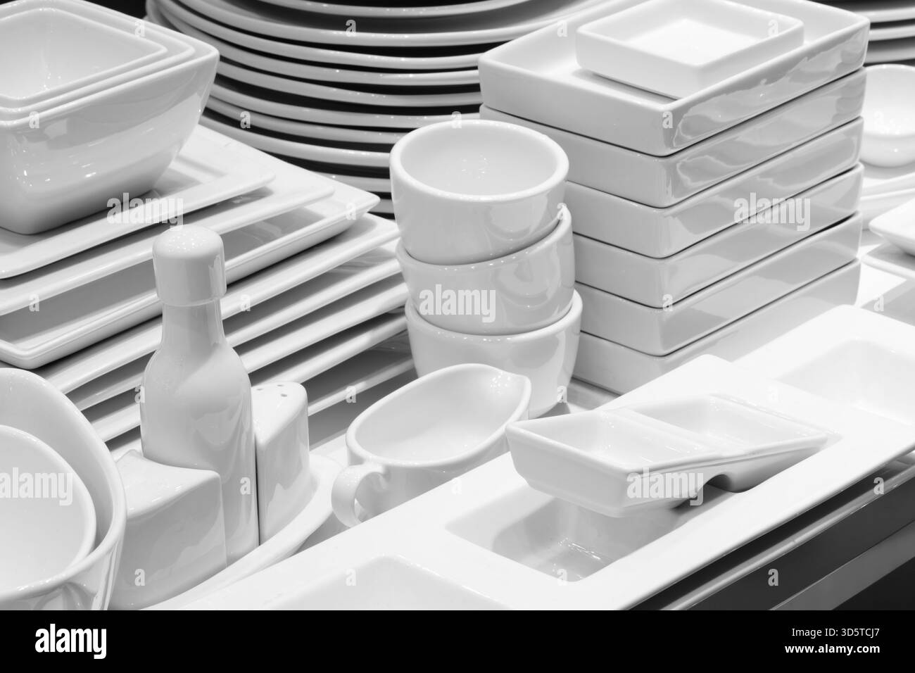Une pile d'assiettes et de bols blancs. Un bol repose sur une pile d'assiettes. Vaisselle de restaurant avant table, concept de service de restaurant d'hôtel. Banque D'Images