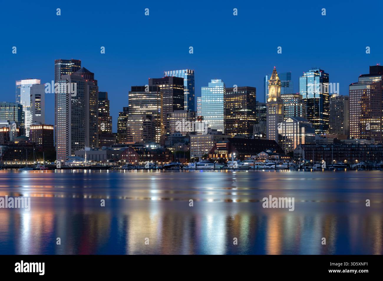 Une belle vue du lever du soleil sur les gratte-ciel du centre-ville de Boston, vue de l'est de Boston à travers le port, avec la tour Custom House. Banque D'Images