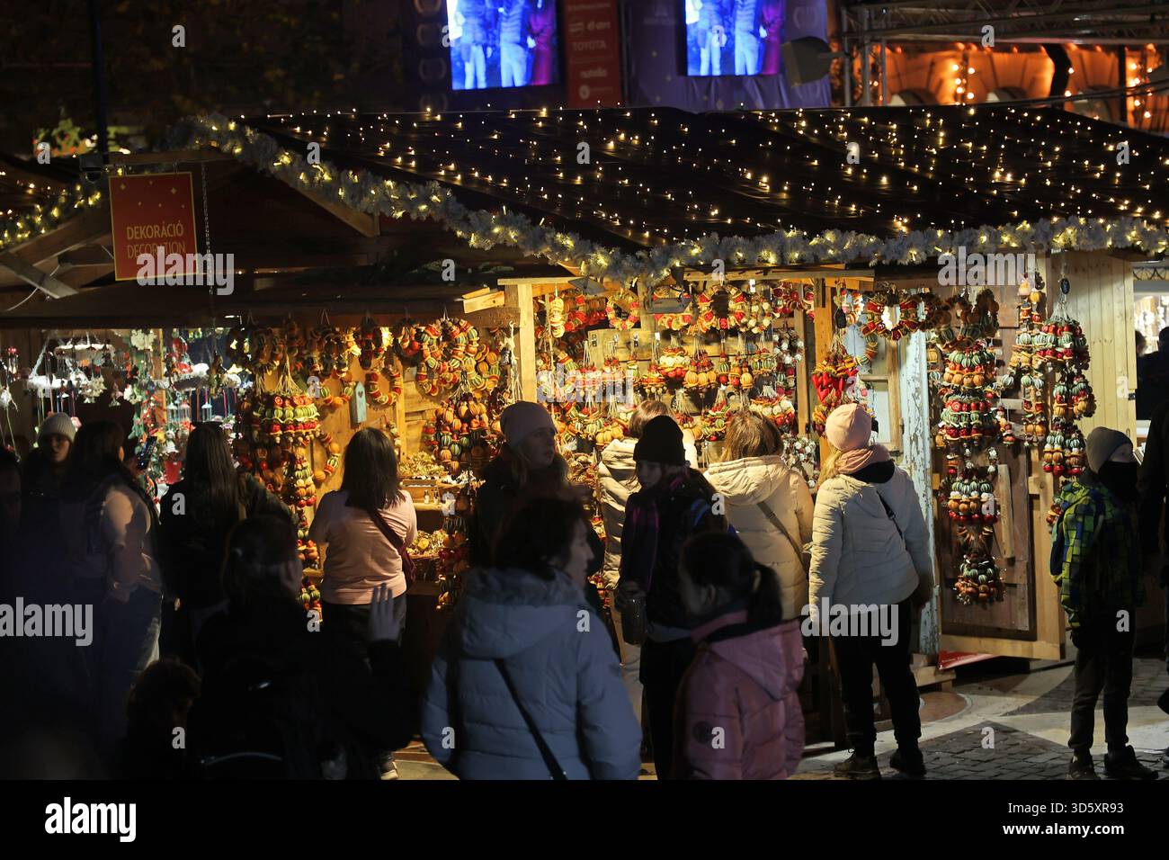 Des gens debout devant un vendeur de rue au marché de Noël de Budapest, Hongrie Banque D'Images