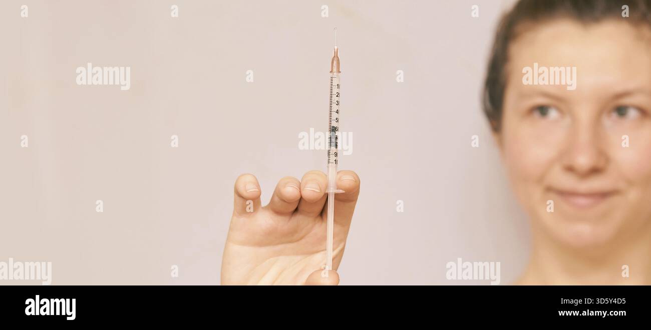 La fille tient l'injection d'insuline dans la main. Visage flou. Vaccin contre le virus ANRI. Contexte infirmier femme. Médecine science concept de traitement. Hea médical COVID19 Banque D'Images