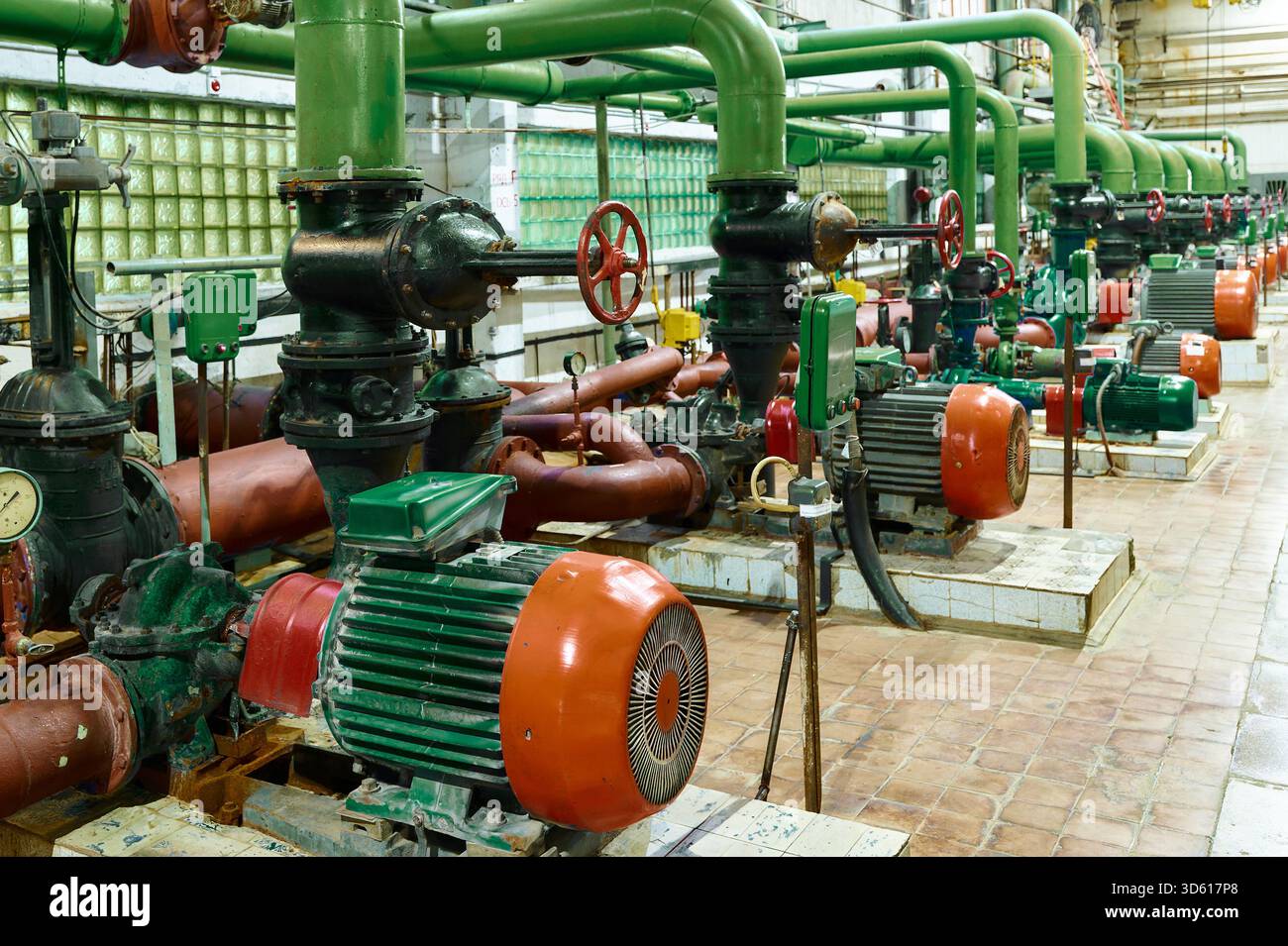 Station de pompage industrielle avec tuyauterie verte et moteurs dans une installation montrant les machines et l'équipement Banque D'Images