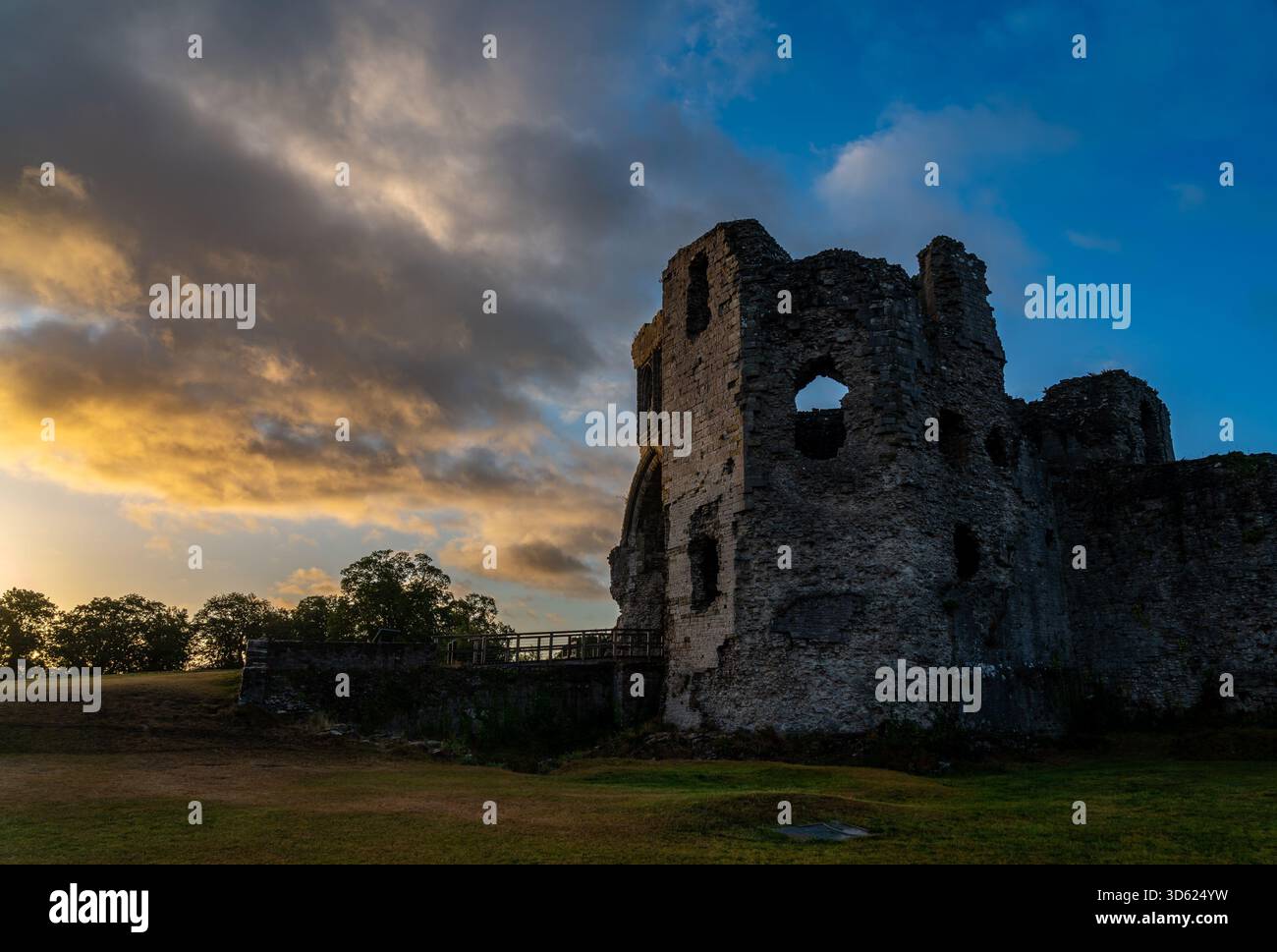 Le soleil du matin projette de la lumière dorée sur les murs de pierre accidentés du château de Denbigh Banque D'Images