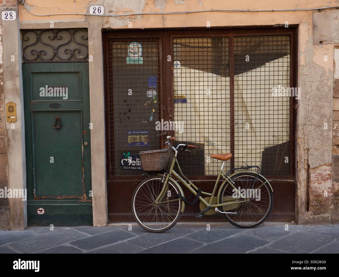 Une vieille femme vélo appuyé contre la fenêtre d'un vieux magasin vide à Lucca Toscane Italie Banque D'Images