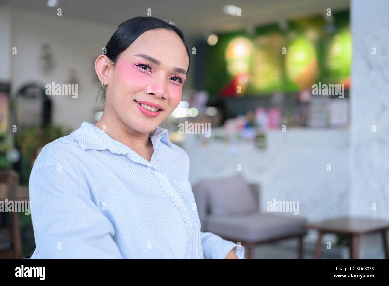 Portrait d'un jeune transgenre thaïlandais avec maquillage et cheveux longs. Concept d'expression de genre, fierté LGBTQ et inclusivité montrant authenti Banque D'Images