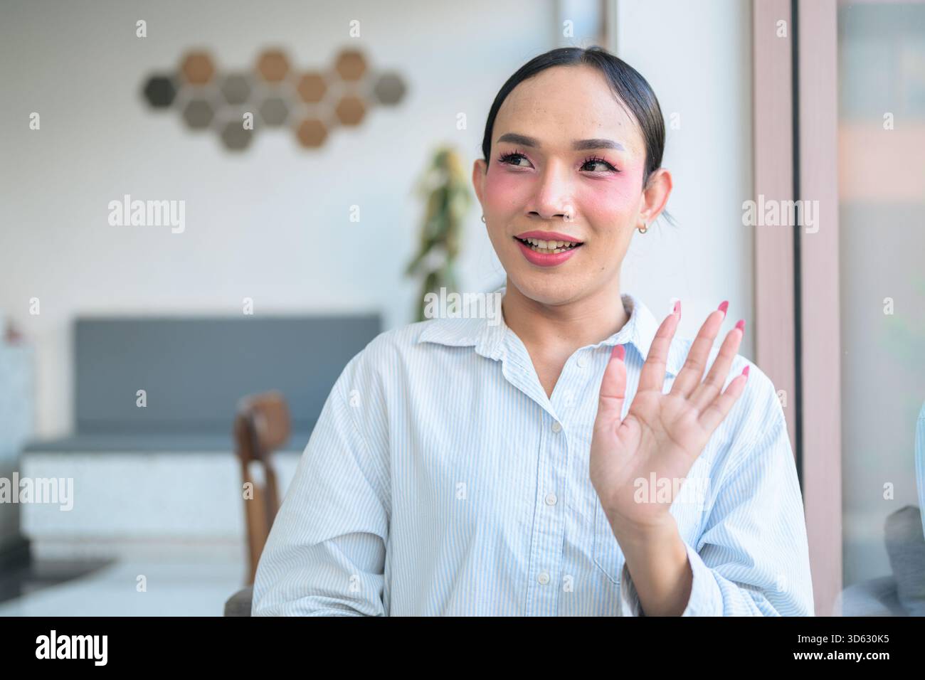Portrait d'un jeune transgenre thaïlandais avec maquillage et cheveux longs. Concept d'expression de genre, fierté LGBTQ et inclusivité montrant authenti Banque D'Images