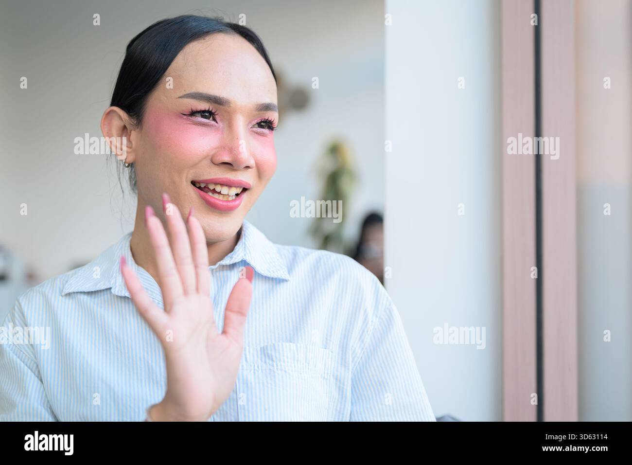 Portrait d'un jeune transgenre thaïlandais avec maquillage et cheveux longs. Concept d'expression de genre, fierté LGBTQ et inclusivité montrant authenti Banque D'Images