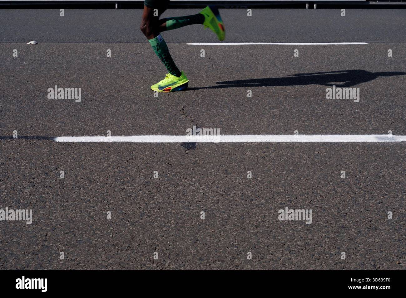 Jambes et ombre d'un athlète coureur lors de la course sur route camarades Marathon tenue en Afrique du Sud. Banque D'Images