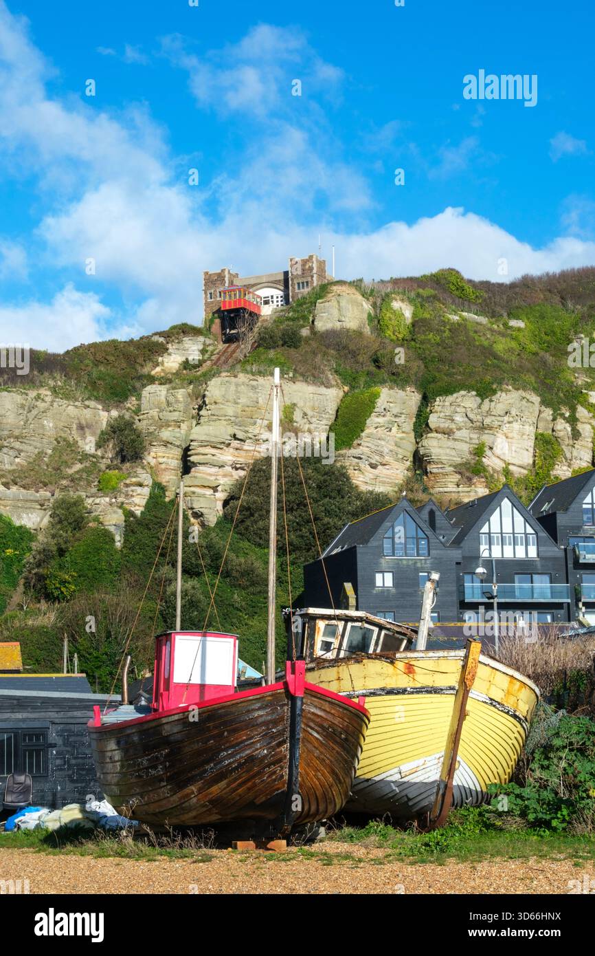 Vieux bateaux de pêche sur la plage de Hastings Old Town stade à Rock-a-Nore, avec East Hill Cliffs et Cliff Lift, East Sussex, Royaume-Uni Banque D'Images