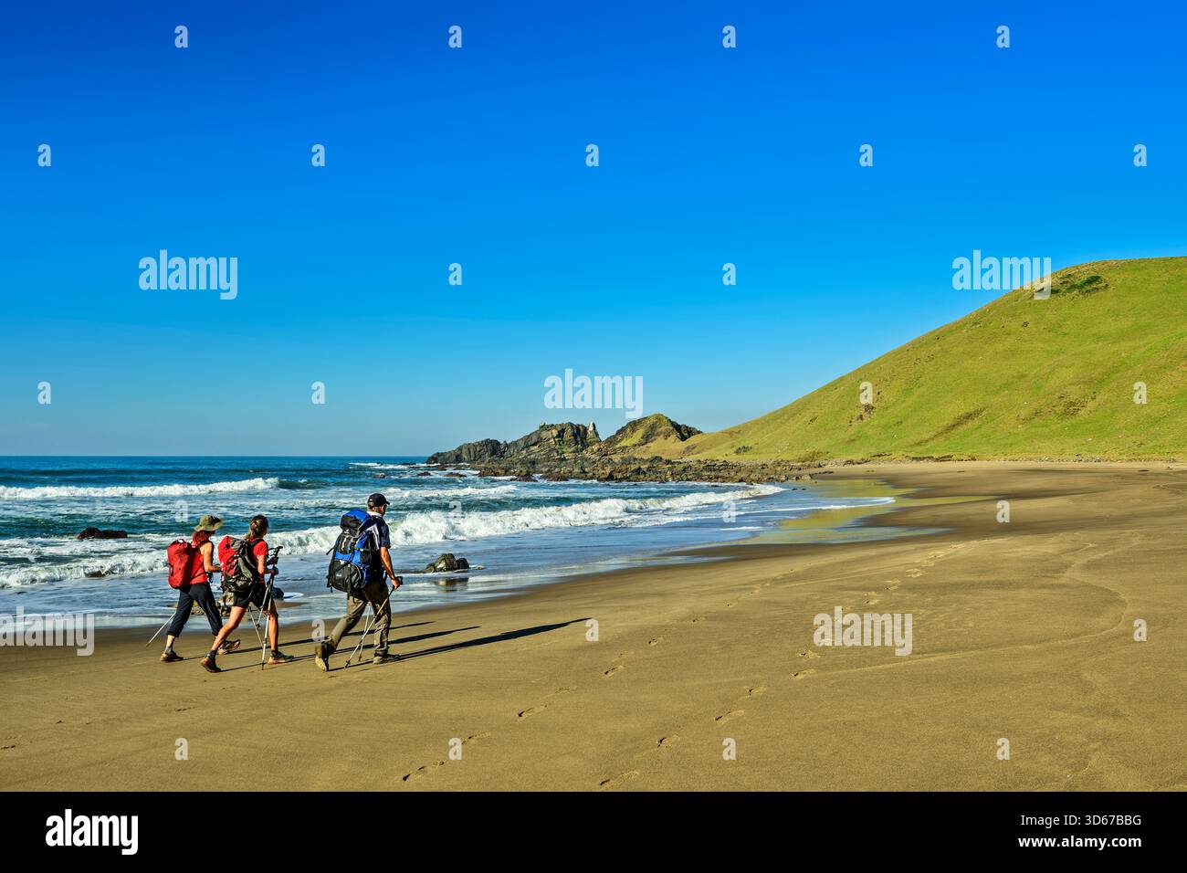 Trois personnes faisant de la randonnée sur une plage de sable sur l'océan Indien, Wild Coast Trail, Wild Coast, Eastern Cape, Afrique du Sud Banque D'Images