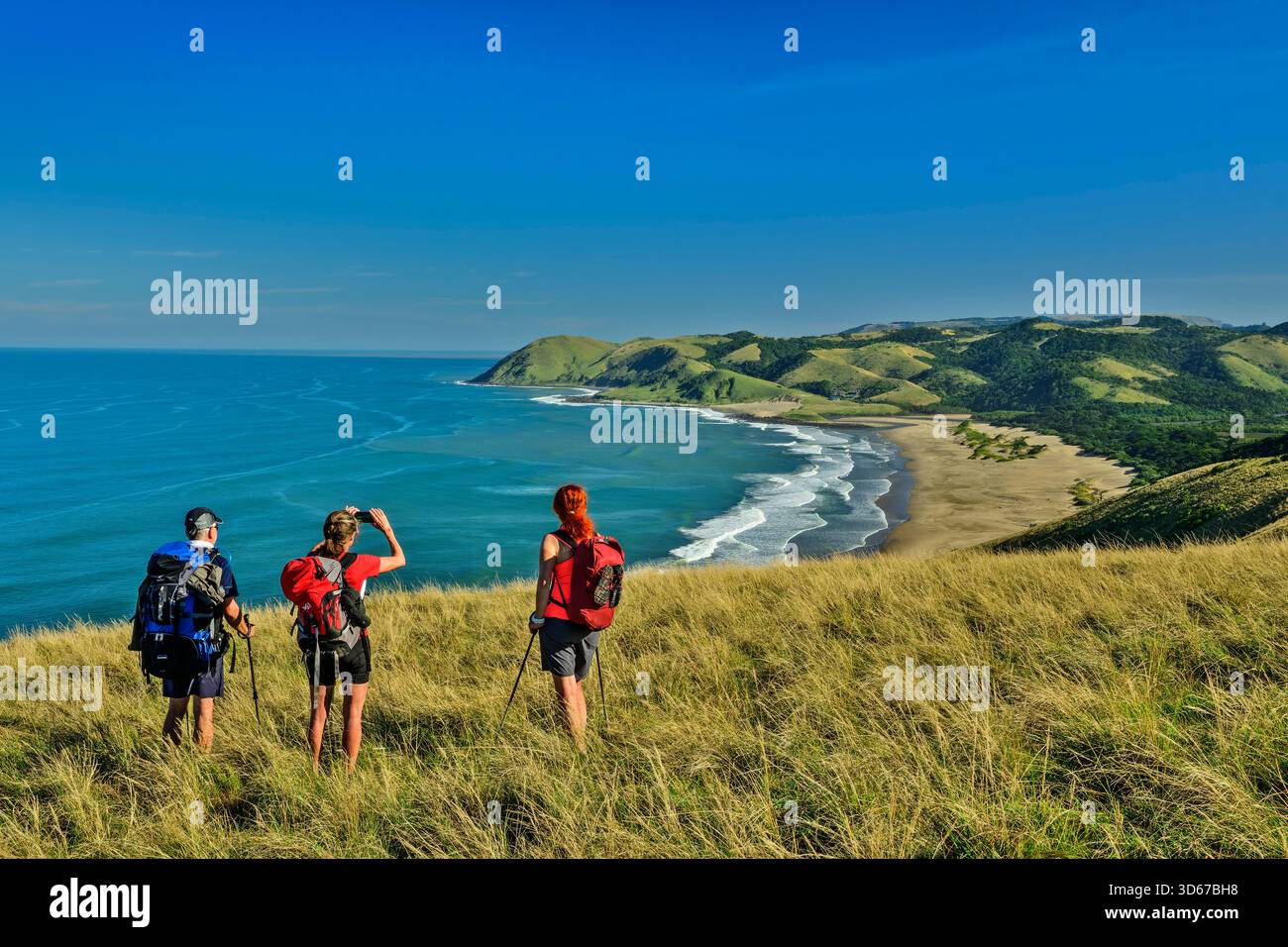 Trois personnes faisant de la randonnée en regardant une plage de sable sur la côte de l'océan Indien, Mnatafufu Bay, Wild Coast Trail, Wild Coast, Eastern Cape, Afrique du Sud Banque D'Images