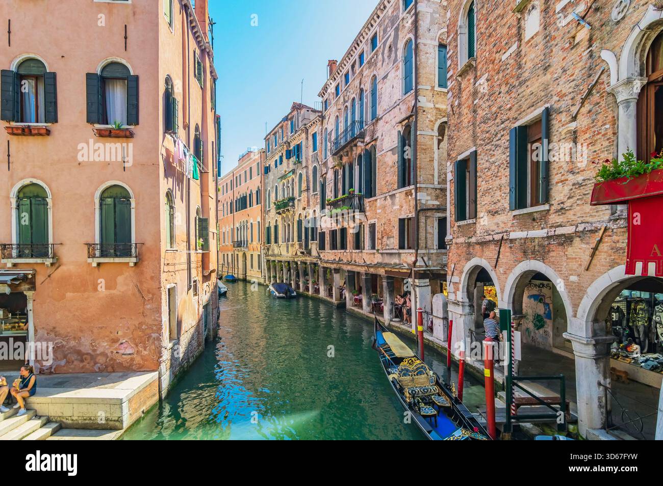 Vue sur un bras latéral du Grand canal, avec des bateaux et des façades colorées de maison, Venise, Italie Banque D'Images