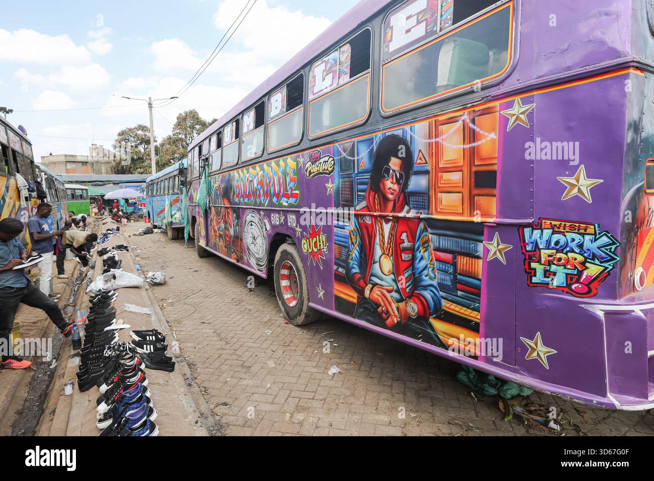 Marchands de chaussures d'occasion vus près d'un portrait graffiti de feu Michael Joseph Jackson, chanteur, compositeur, danseur et philanthrope américain. Surnommé le « Roi de la Pop », peint sur un matatu (mini bus) au terminus de bus muthurwa Nairobi. Matatus sont des bus ou des mini-bus responsables d'un grand ?pourcentage des transports publics dans et autour de Nairobi.  ?Les transports en commun à Nairobi sont si populaires et uniques ? a cause de la culture matutu. Dans la capitale du Kenya, les transports publics ne se limitent pas à se rendre d’un endroit à un autre. C’est une culture, et vous commencerez à comprendre pourquoi lorsque vous serez confronté à l’esprit Banque D'Images
