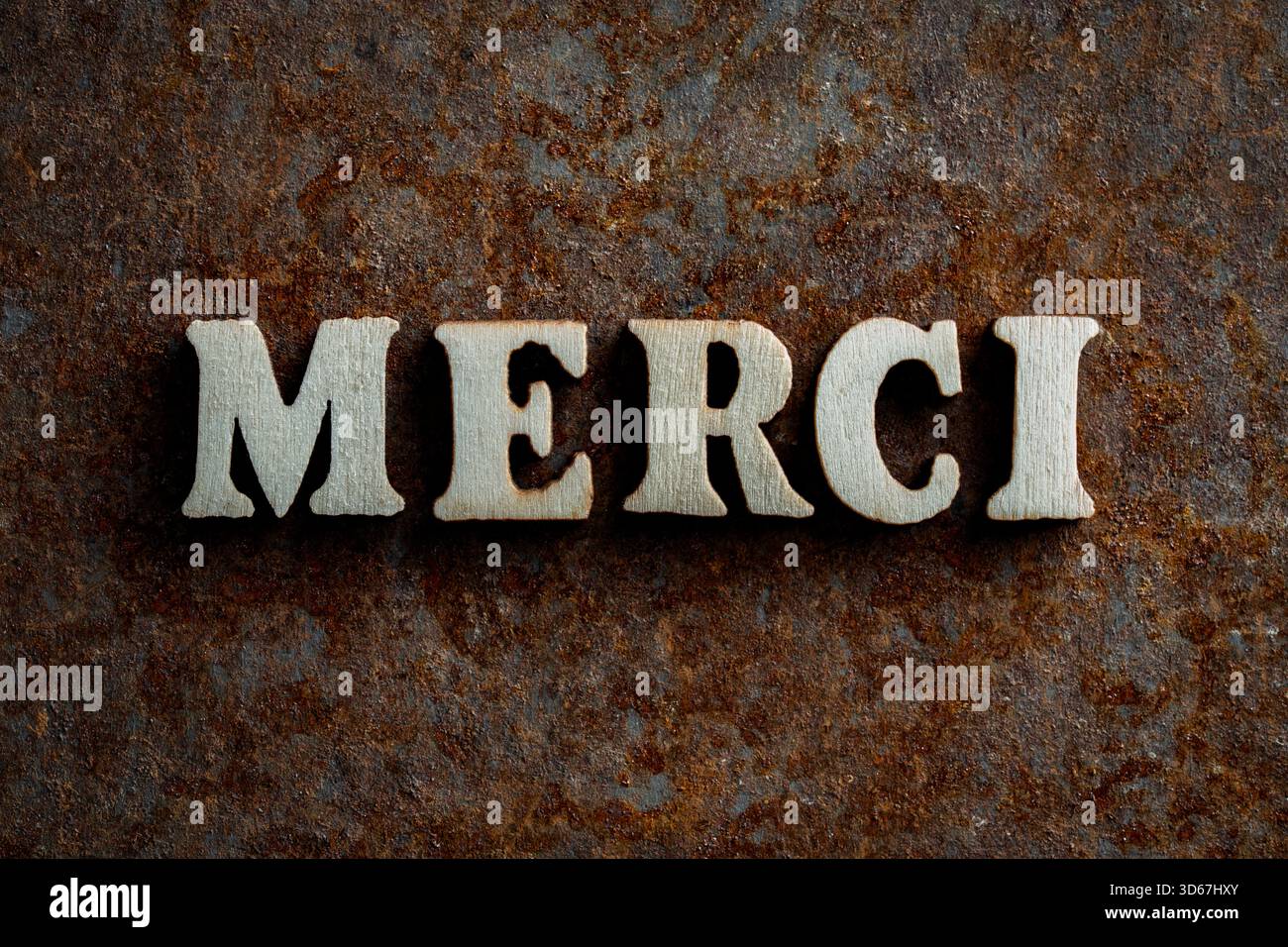 Lettres en bois avec le mot merci sur une vieille surface rouillée, gros plan, vue de dessus. Merci en français merci de l'alphabet lettre en bois Banque D'Images