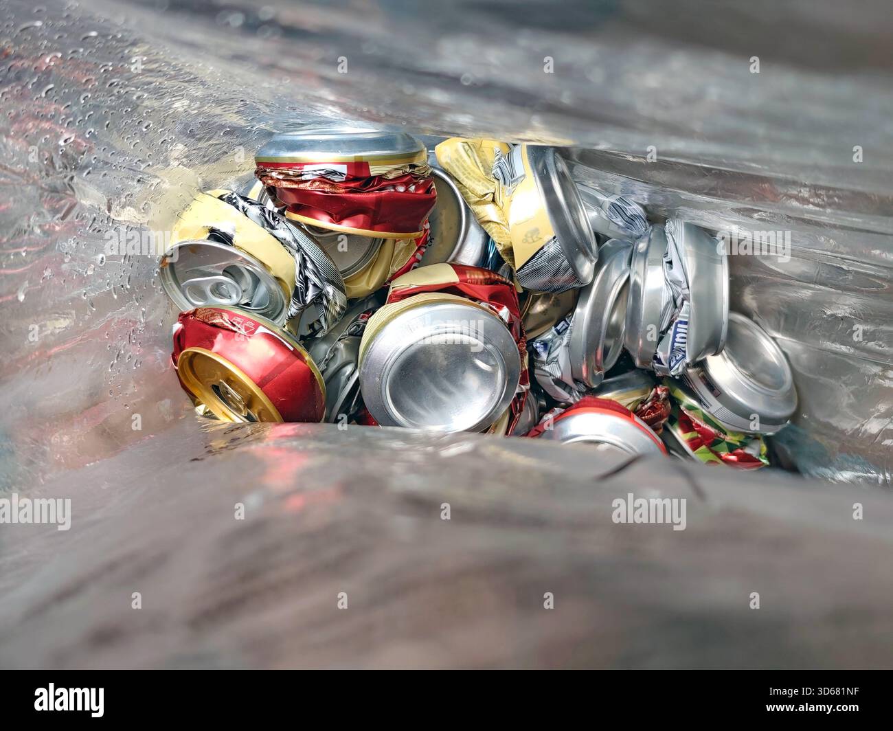 Canettes en aluminium déchiquetées dans un sac en plastique, prêtes à être recyclées. Symbole de protection de l'environnement, de gestion des déchets et de la culture de consommation, recyclables Banque D'Images