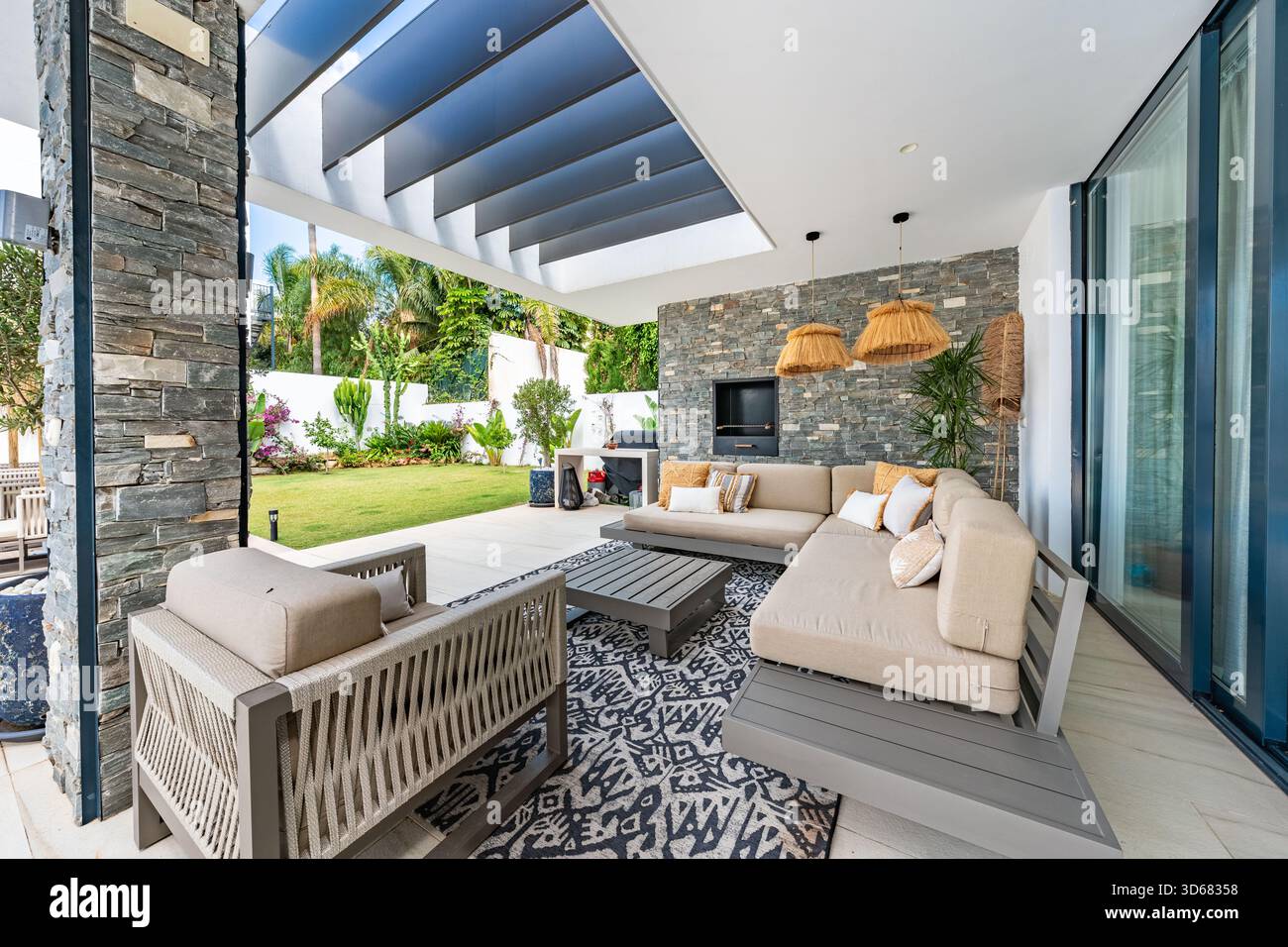 Patio extérieur avec sièges confortables et vue sur le jardin dans une luxueuse maison méditerranéenne Banque D'Images