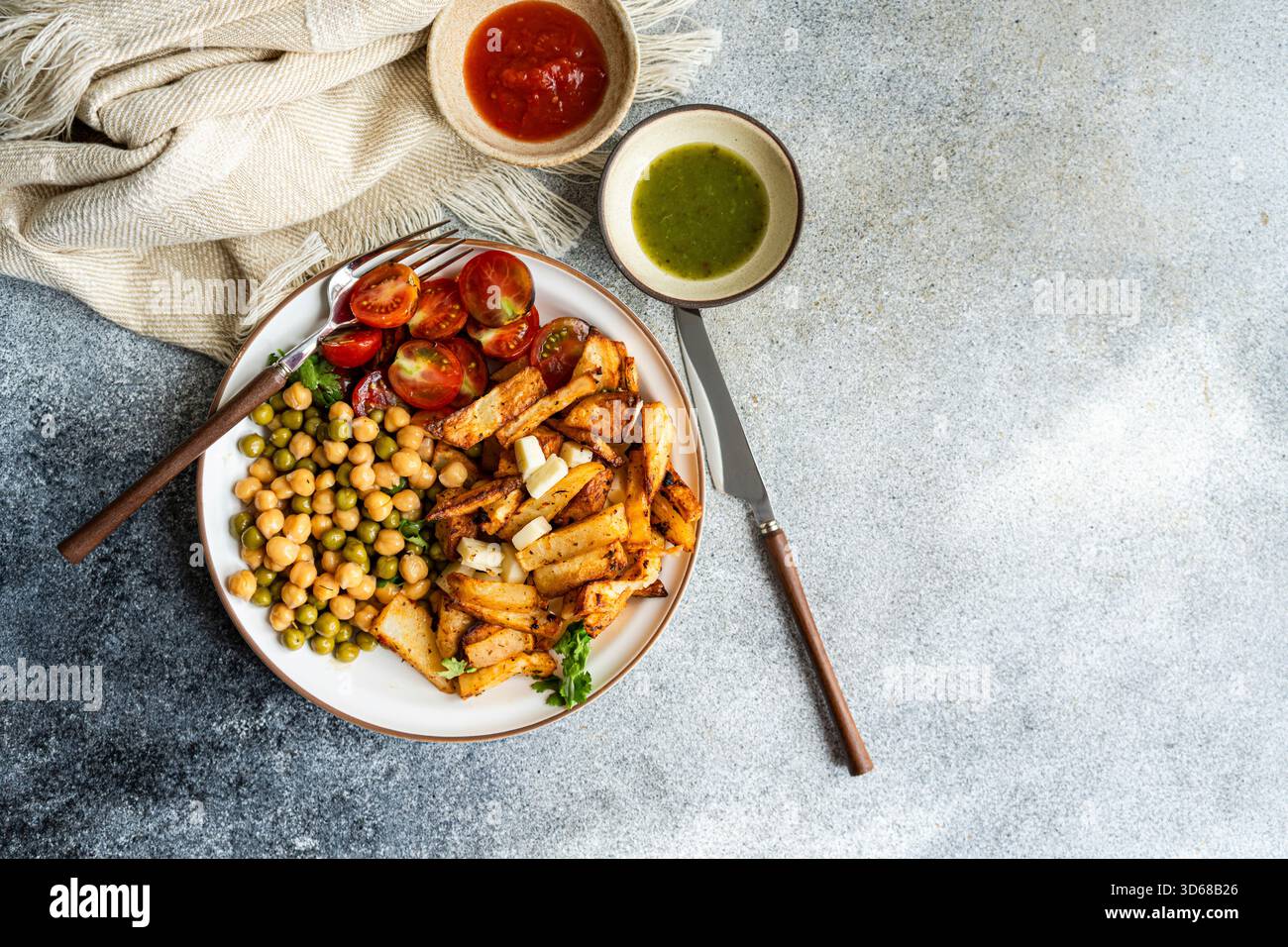 Petit déjeuner copieux avec pommes de terre, tomates et petits pois Banque D'Images