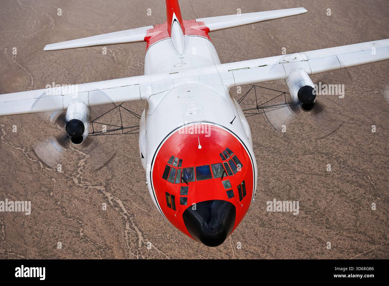 Lockheed C-130A Hercules (N117TG) exploité par International Air Response lors d'une mission de photographie air-air au-dessus de l'Arizona. Ce Hercules de premier modèle, série 182-3018, est capturé en vol au-dessus du paysage désertique, mettant en valeur le profil distinctif et la conception traditionnelle du transport à turbopropulseurs à quatre moteurs classique Banque D'Images