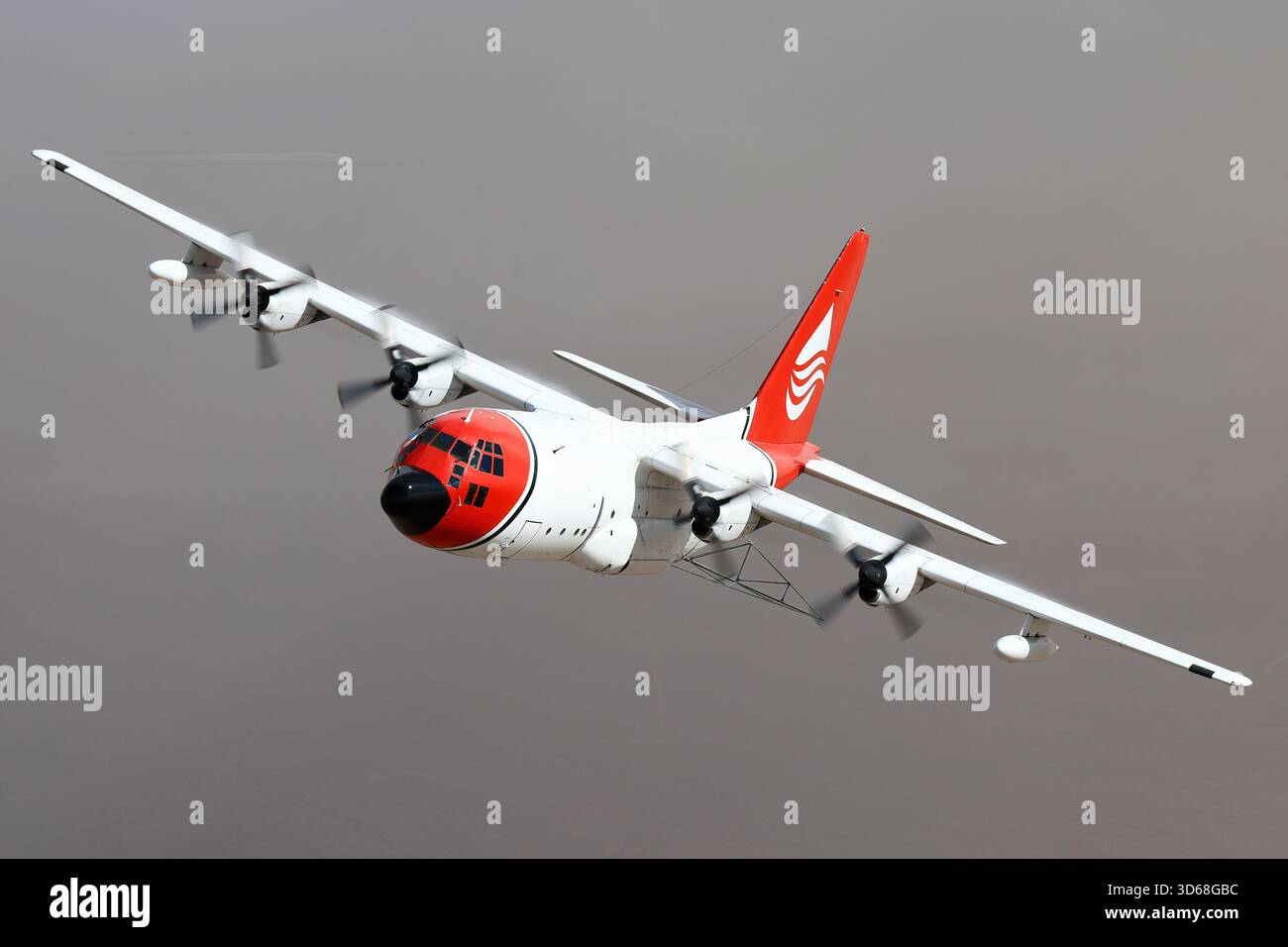 Lockheed C-130A Hercules (N117TG) exploité par International Air Response lors d'une mission de photographie air-air au-dessus de l'Arizona. Ce Hercules de premier modèle, série 182-3018, est capturé en vol au-dessus du paysage désertique, mettant en valeur le profil distinctif et la conception traditionnelle du transport à turbopropulseurs à quatre moteurs classique Banque D'Images