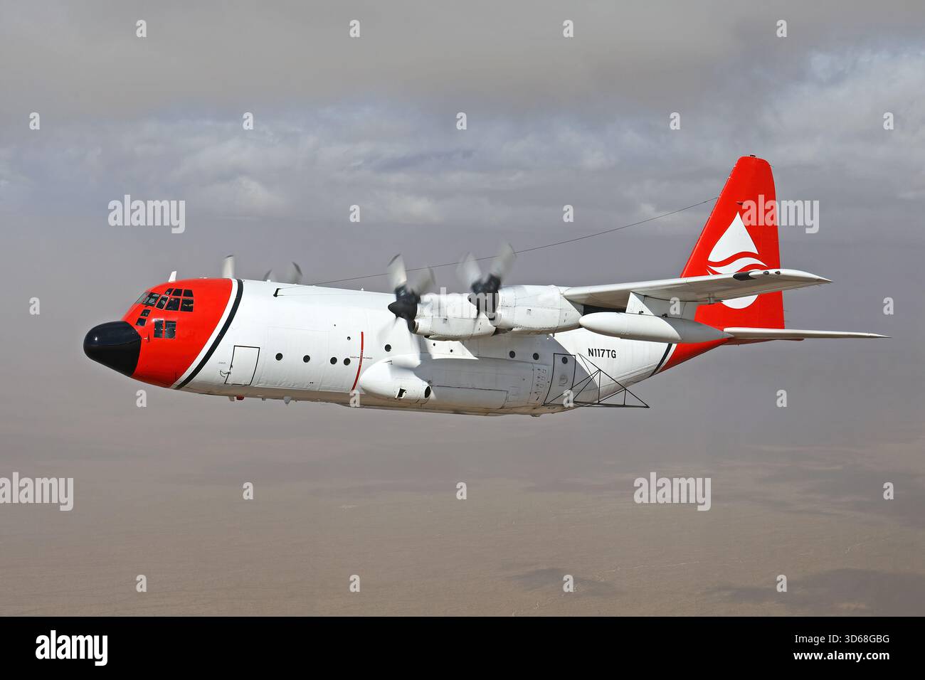 Lockheed C-130A Hercules (N117TG) exploité par International Air Response lors d'une mission de photographie air-air au-dessus de l'Arizona. Ce Hercules de premier modèle, série 182-3018, est capturé en vol au-dessus du paysage désertique, mettant en valeur le profil distinctif et la conception traditionnelle du transport à turbopropulseurs à quatre moteurs classique Banque D'Images