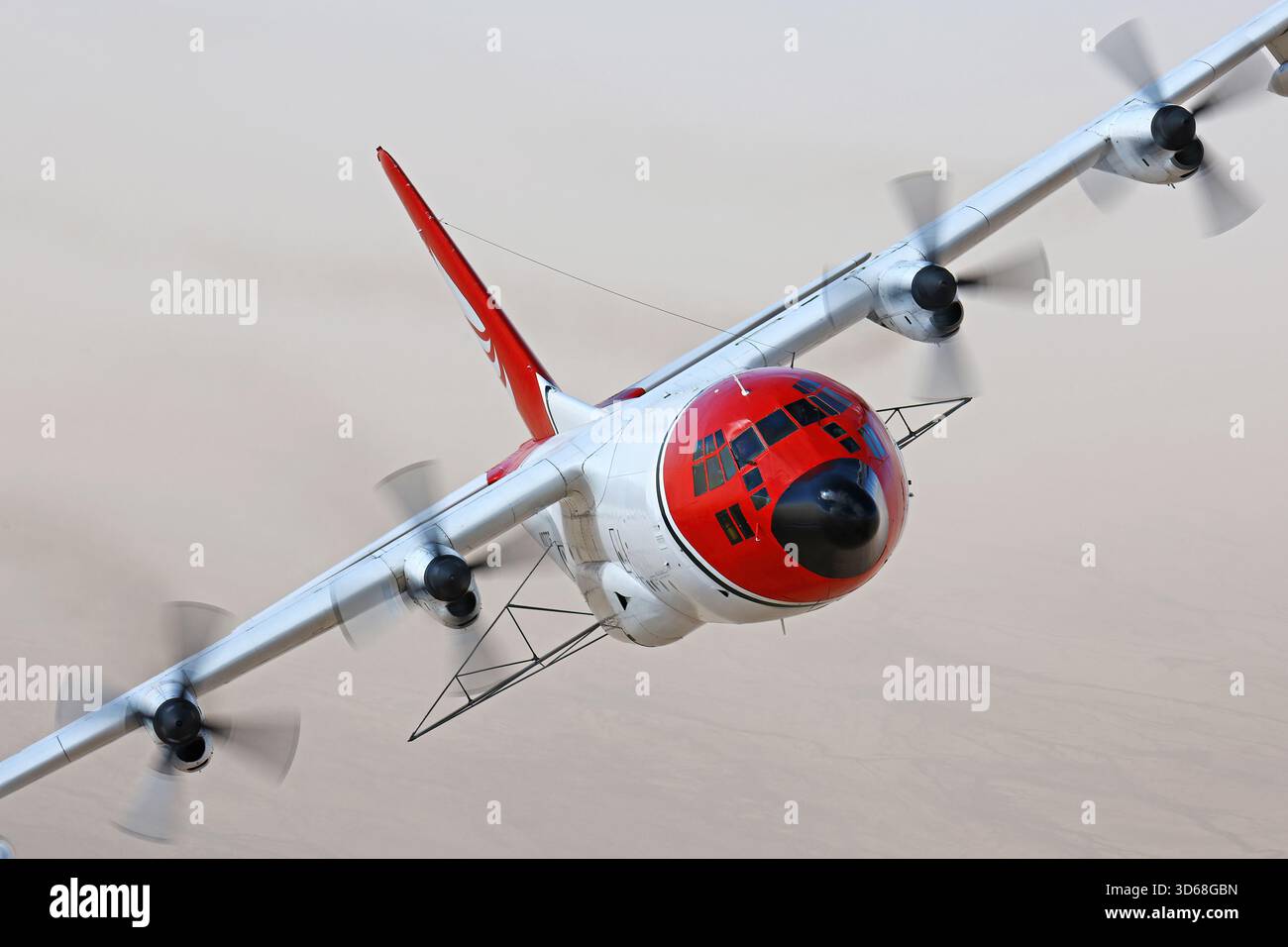 Lockheed C-130A Hercules (N117TG) exploité par International Air Response lors d'une mission de photographie air-air au-dessus de l'Arizona. Ce Hercules de premier modèle, série 182-3018, est capturé en vol au-dessus du paysage désertique, mettant en valeur le profil distinctif et la conception traditionnelle du transport à turbopropulseurs à quatre moteurs classique Banque D'Images