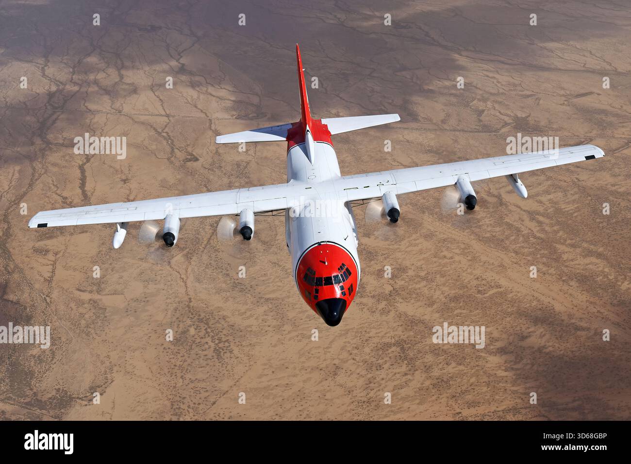 Lockheed C-130A Hercules (N117TG) exploité par International Air Response lors d'une mission de photographie air-air au-dessus de l'Arizona. Ce Hercules de premier modèle, série 182-3018, est capturé en vol au-dessus du paysage désertique, mettant en valeur le profil distinctif et la conception traditionnelle du transport à turbopropulseurs à quatre moteurs classique Banque D'Images