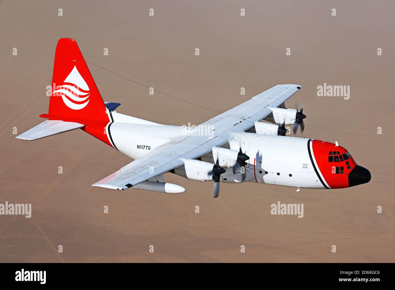 Lockheed C-130A Hercules (N117TG) exploité par International Air Response lors d'une mission de photographie air-air au-dessus de l'Arizona. Ce Hercules de premier modèle, série 182-3018, est capturé en vol au-dessus du paysage désertique, mettant en valeur le profil distinctif et la conception traditionnelle du transport à turbopropulseurs à quatre moteurs classique Banque D'Images