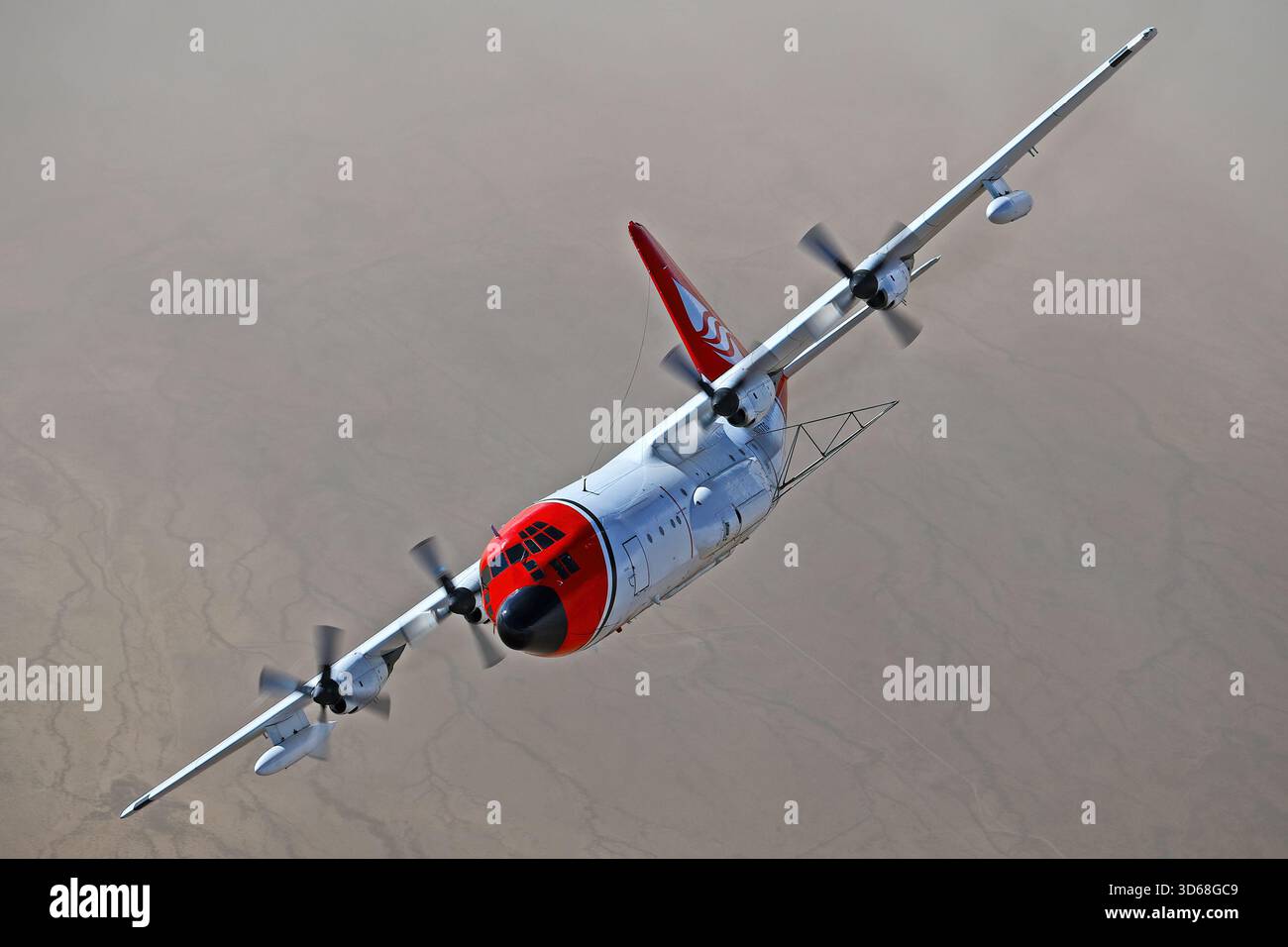 Lockheed C-130A Hercules (N117TG) exploité par International Air Response lors d'une mission de photographie air-air au-dessus de l'Arizona. Ce Hercules de premier modèle, série 182-3018, est capturé en vol au-dessus du paysage désertique, mettant en valeur le profil distinctif et la conception traditionnelle du transport à turbopropulseurs à quatre moteurs classique Banque D'Images