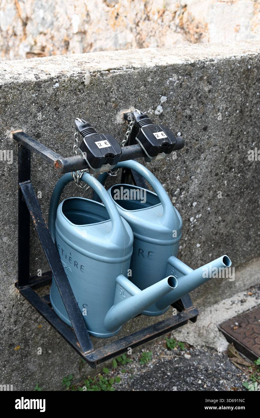 Serrures à pièces avec fentes à pièces pour la location d'arrosoirs en plastique vert pour deux euros au cimetière Cabris France Banque D'Images